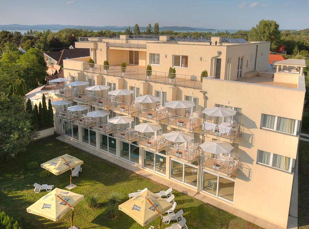una vista aérea de un hotel con mesas y sombrillas en Két Korona Konferencia és Wellness Hotel, en Balatonszárszó