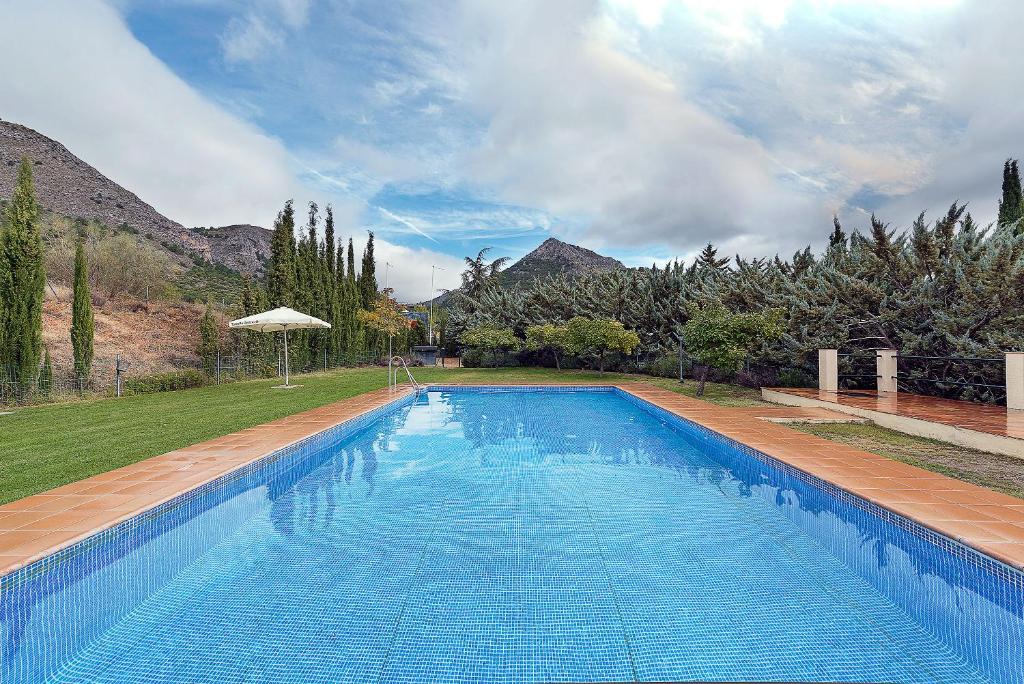 una gran piscina azul en un patio en Caserio del Colmenar, en Huétor Santillán