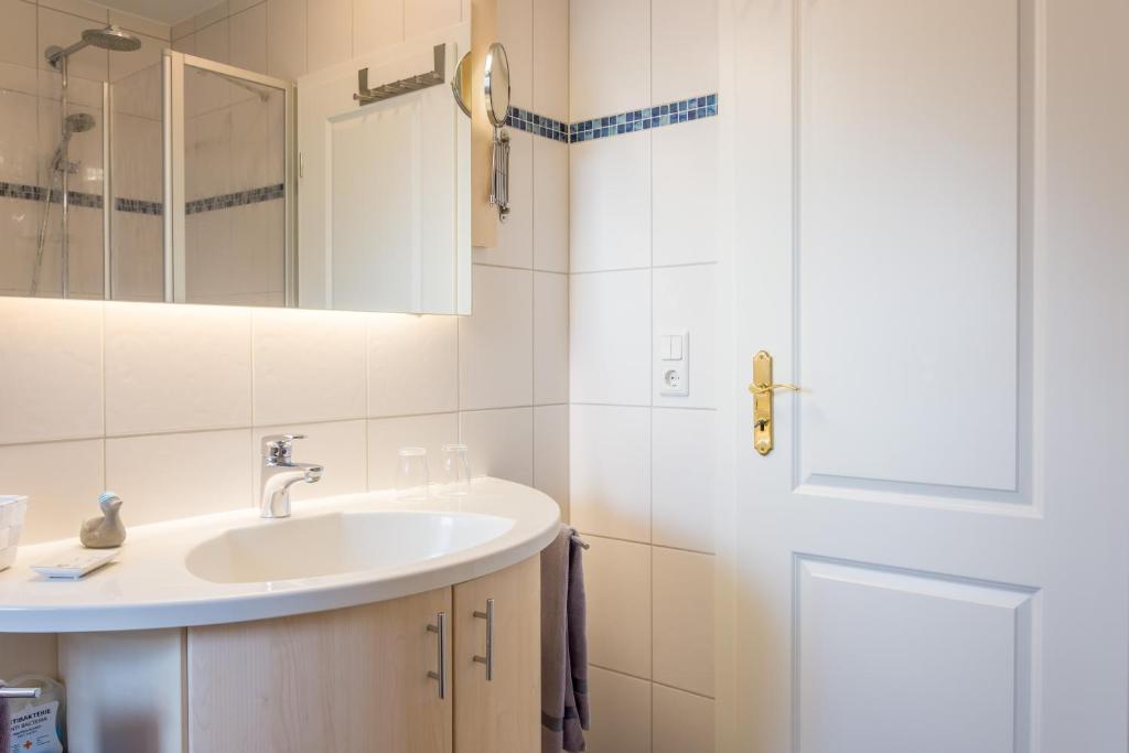 y baño con lavabo y espejo. en Gasthaus Knudsen en Utersum