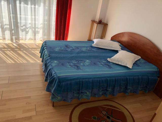 a bedroom with a bed with a blue comforter at Hotel Sucidava in Corabia