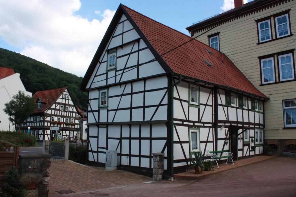 een zwart-wit gebouw met een rood dak bij Ferienwohnung Familie Harseim in Ruhla
