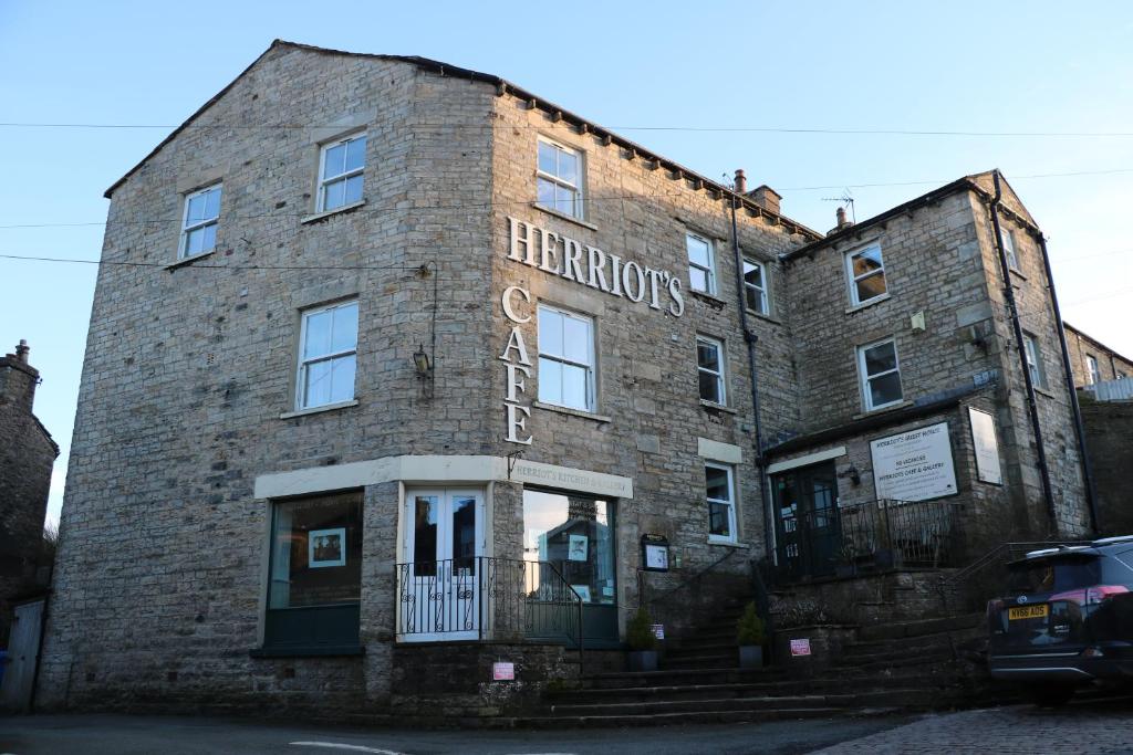 un viejo edificio de ladrillo con un cartel. en Herriot's en Hawes