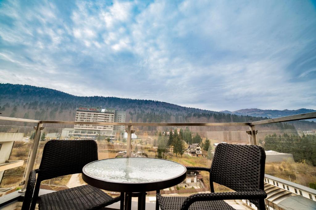 einen Tisch und Stühle auf einem Balkon mit Aussicht in der Unterkunft SinaiaMountainView - Vista in Sinaia