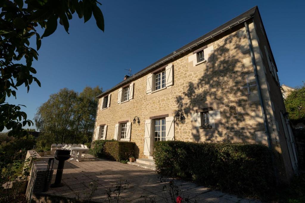 een groot bakstenen gebouw met zijn schaduw aan de zijkant bij La Belle Etoile in Avon-les-Roches