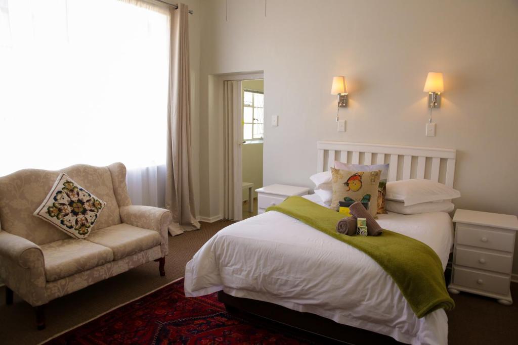 sypialnia z łóżkiem, krzesłem i oknem w obiekcie Twins Guesthouse NO LOAD SHEDDING w mieście King Williamʼs Town