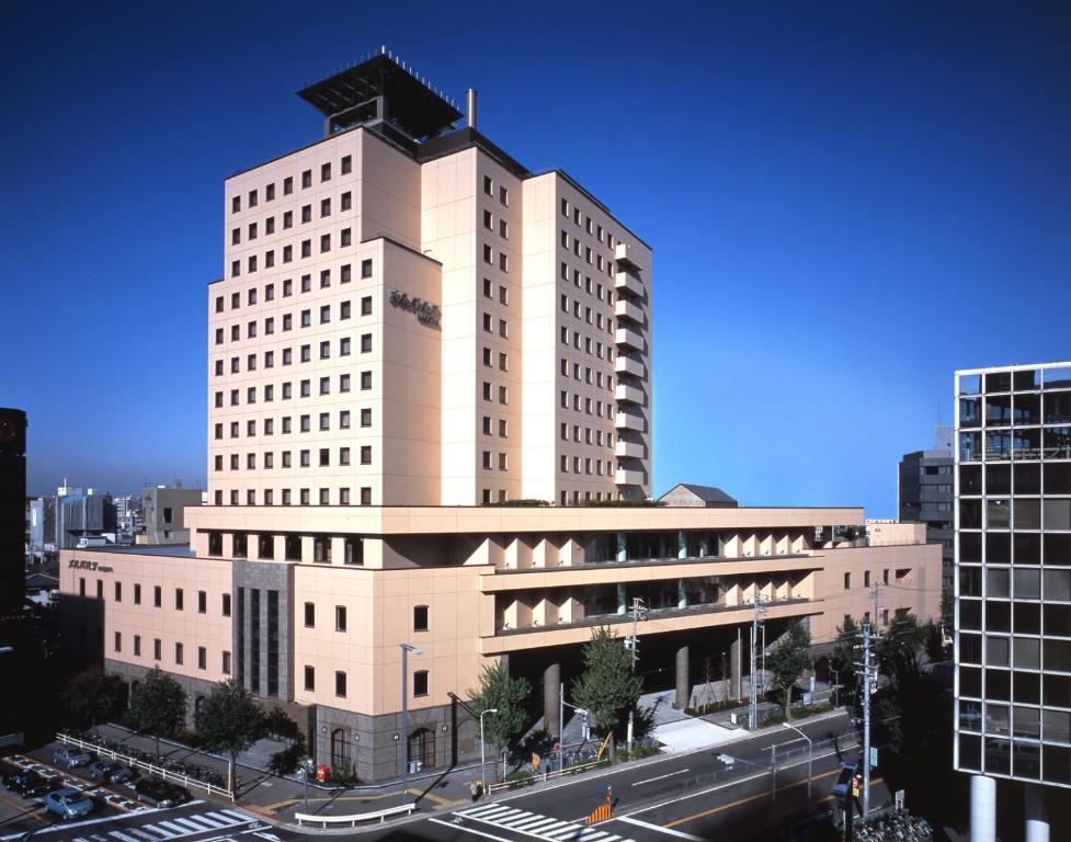 un grand bâtiment blanc avec une tour en haut dans l'établissement Hotel Mielparque Nagoya, à Nagoya