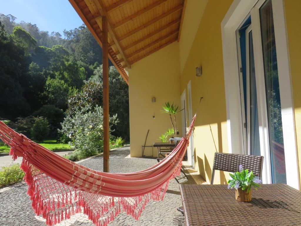 a hammock on the patio of a house at Solar do Carvalho in São Vicente