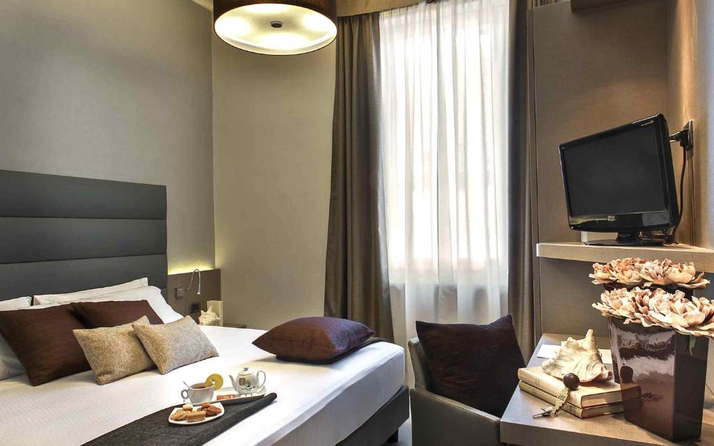 una habitación de hotel con cama y TV y una habitación en Hotel Chivasso, en Chivasso