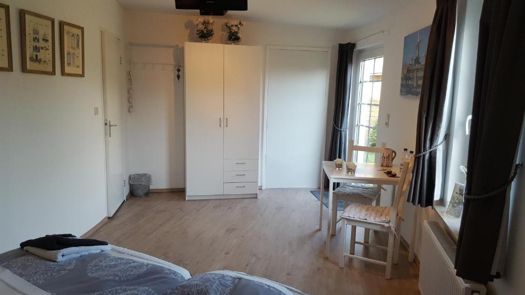 a bedroom with a bed and a desk in a room at De Witte Molen Kranenburg in Kranenburg