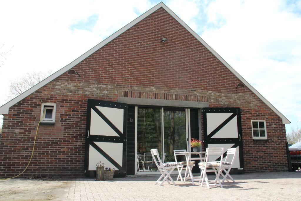 a barn with chairs and a table in front of it at B&B In de Backerije in Zuidwolde