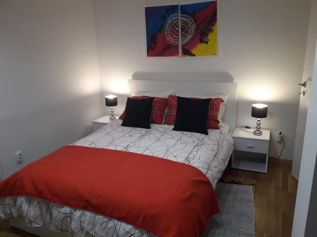 a bedroom with a red and white bed with two lamps at Apartment Rose in Zagreb