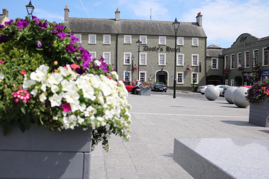 une place de ville avec des fleurs devant un bâtiment dans l'établissement Dooly's Hotel, à Birr