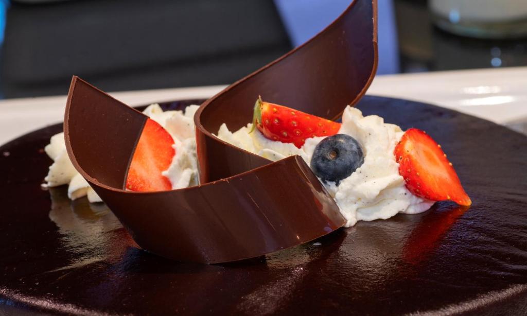 a chocolate dessert with fruit on a black plate at Thon Hotel Opera in Oslo