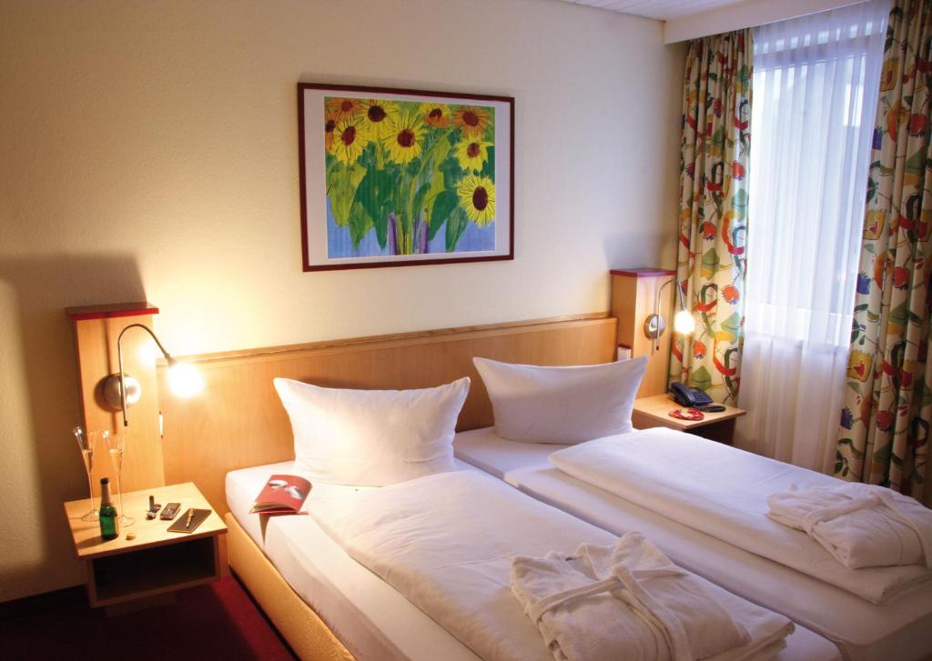 a hotel room with two beds and a picture on the wall at Hotel Garni Elegant in Willingen