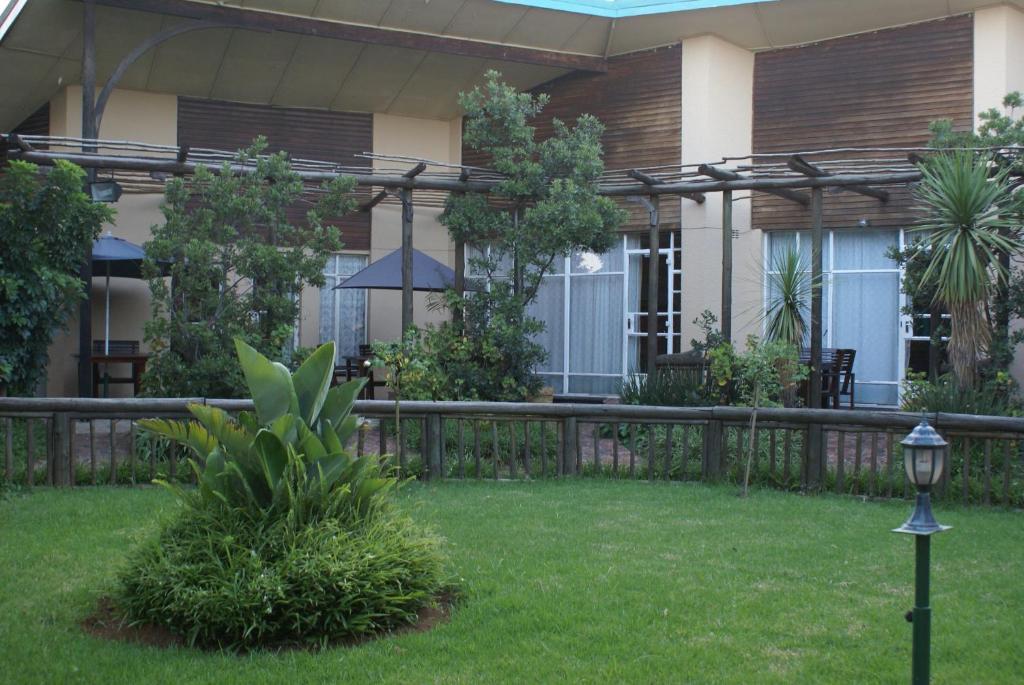 a fence in the yard of a house at Airport Inn Bed and Breakfast in Kempton Park