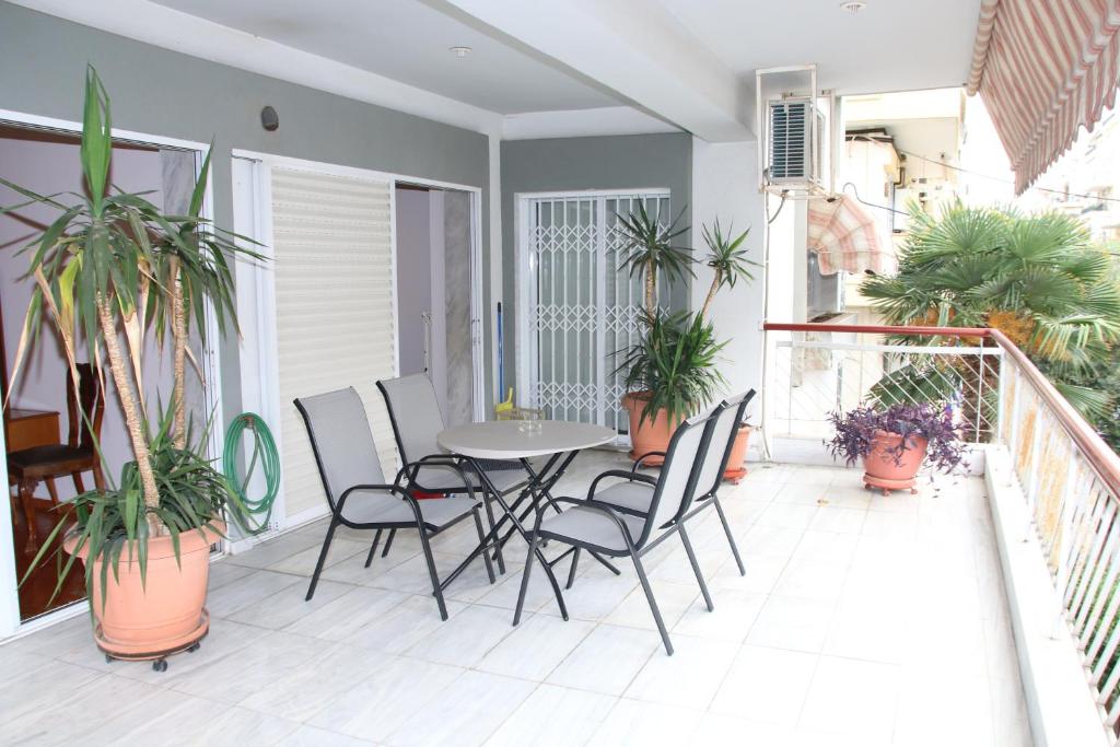 a balcony with a table and chairs and potted plants at Apartment Nikos in Thessaloniki