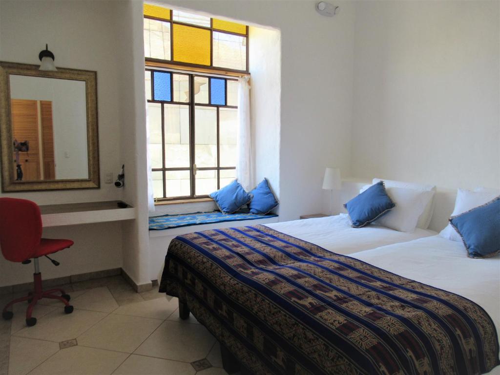 a bedroom with two beds and a mirror and a chair at Apartamento Terra Amata Arica in Arica