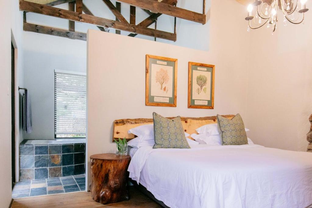 a bedroom with a bed and a wooden stump table at Belvedere Game Ranch in Magudu