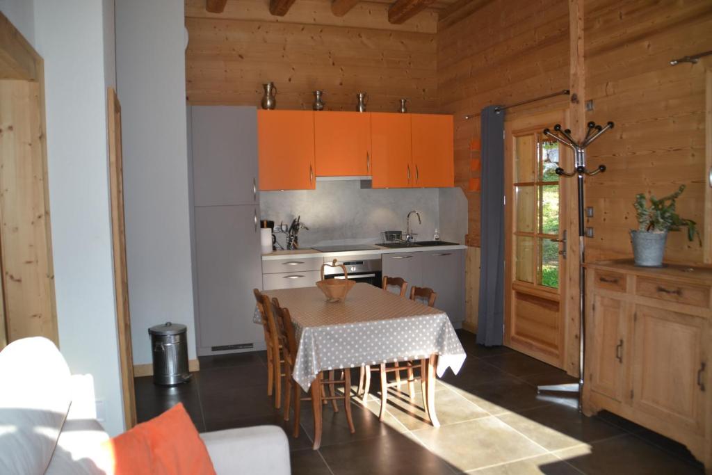 a kitchen with a table and a kitchen with orange cabinets at Chalet des fleurs in Samoëns