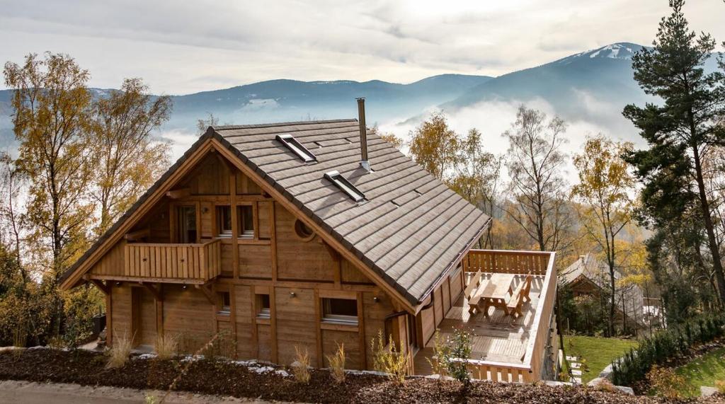 une grande maison en bois avec un toit en gambrel dans l'établissement La Datcha de Liza, à Metzeral