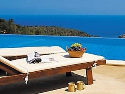 a bed sitting on top of a table next to the ocean at villa iliana in Skiathos