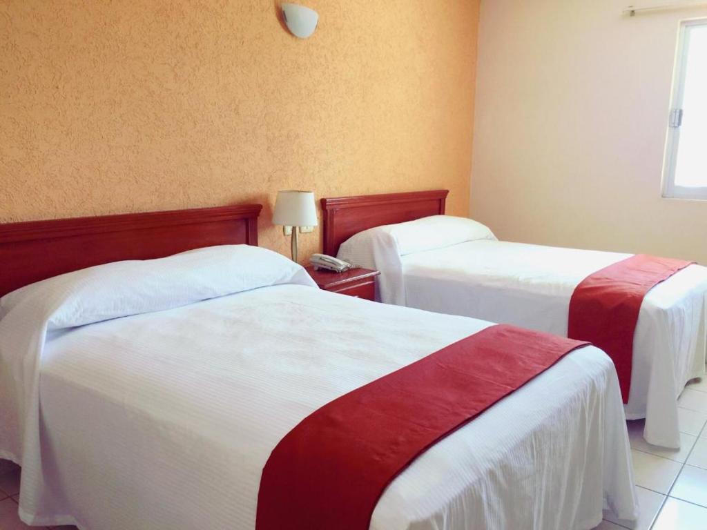 En eller flere senger på et rom på Hotel Villa Campeche