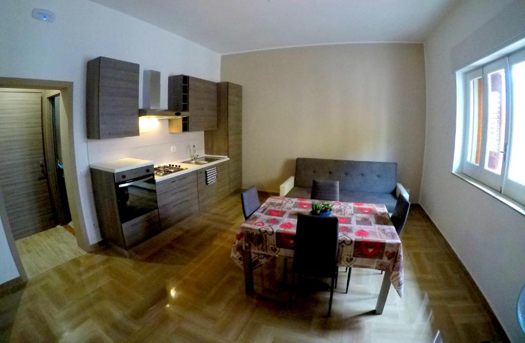 ein Wohnzimmer mit einem Tisch und einer Küche in der Unterkunft Welcome Home Apt. 2 in Pozzallo