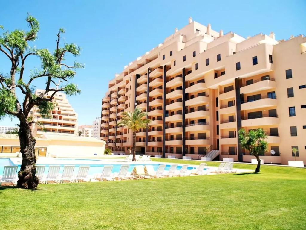 un complejo con piscina y un gran edificio en Awesome apartment in Praia da Rocha en Portimão