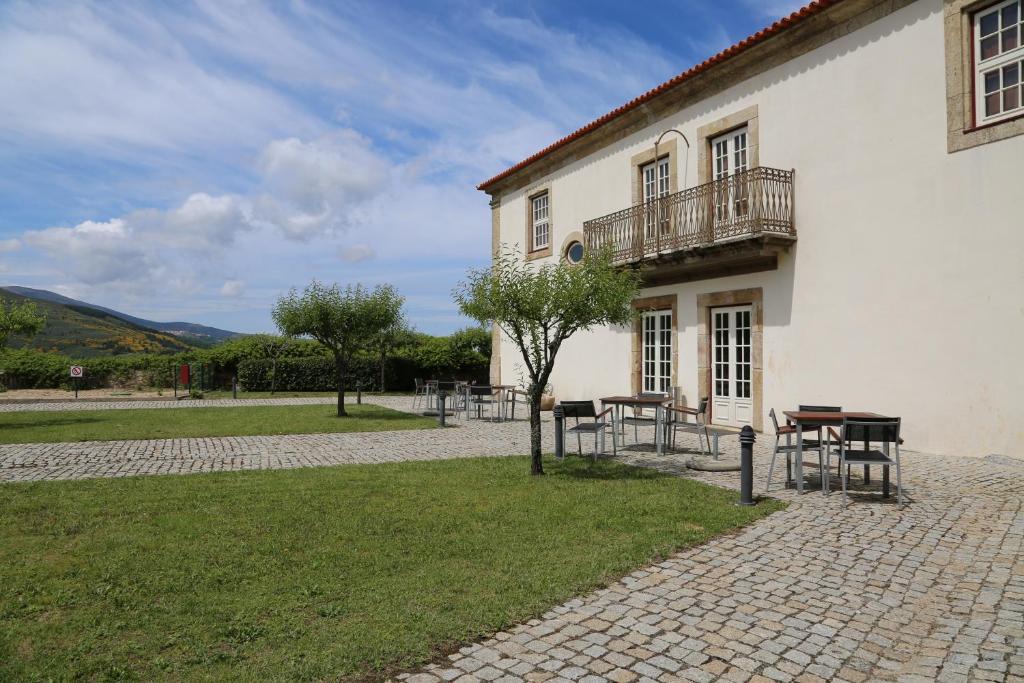 um edifcio com uma mesa e uma varanda em INATEL Linhares da Beira Hotel Rural em Linhares