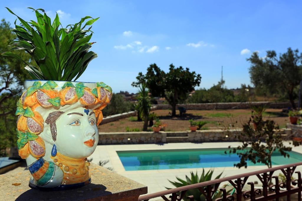 a vase sitting on a ledge next to a pool at Eremo delle Grazie in Ispica