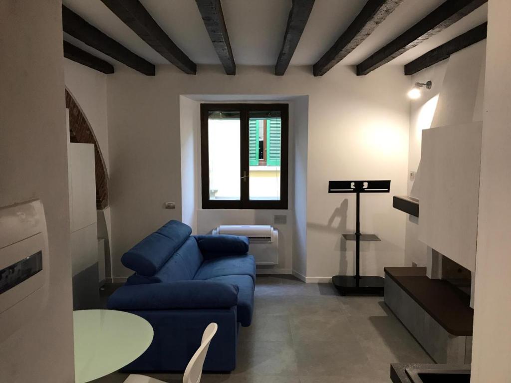 een woonkamer met een blauwe bank en een tafel bij Via Casale - Sweet home in Milaan