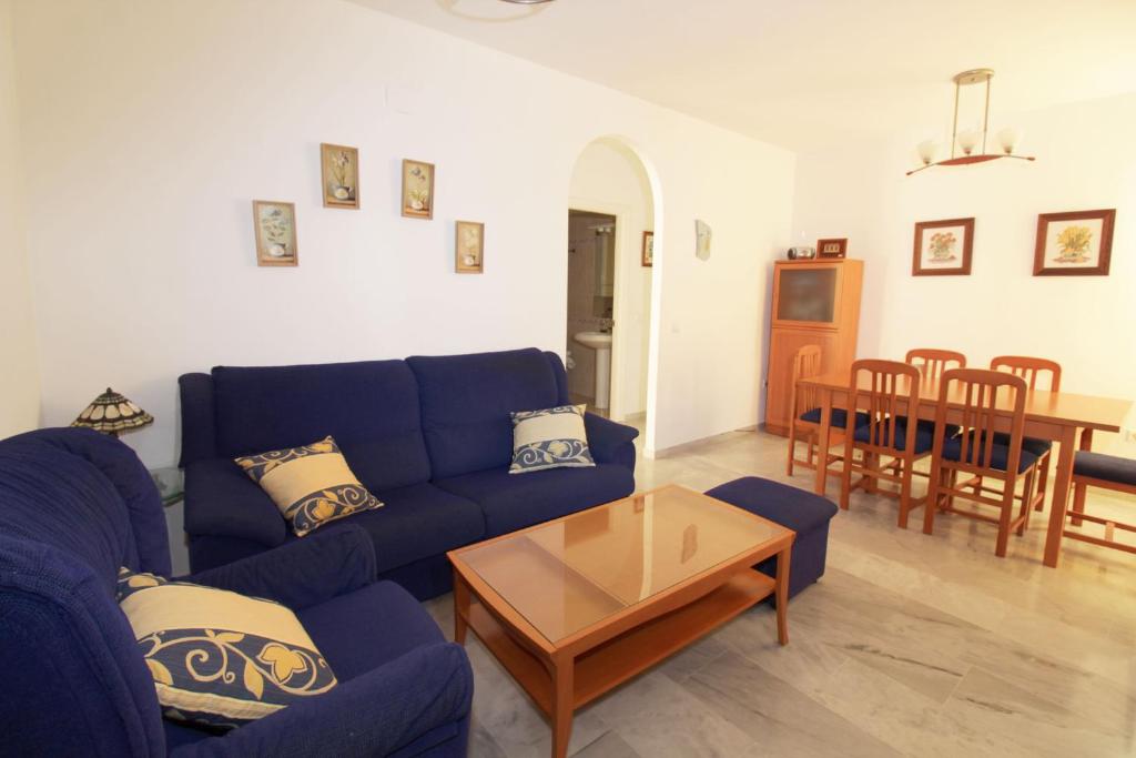 een woonkamer met een blauwe bank en een tafel bij Apartamento Calle Cruz in Fuengirola