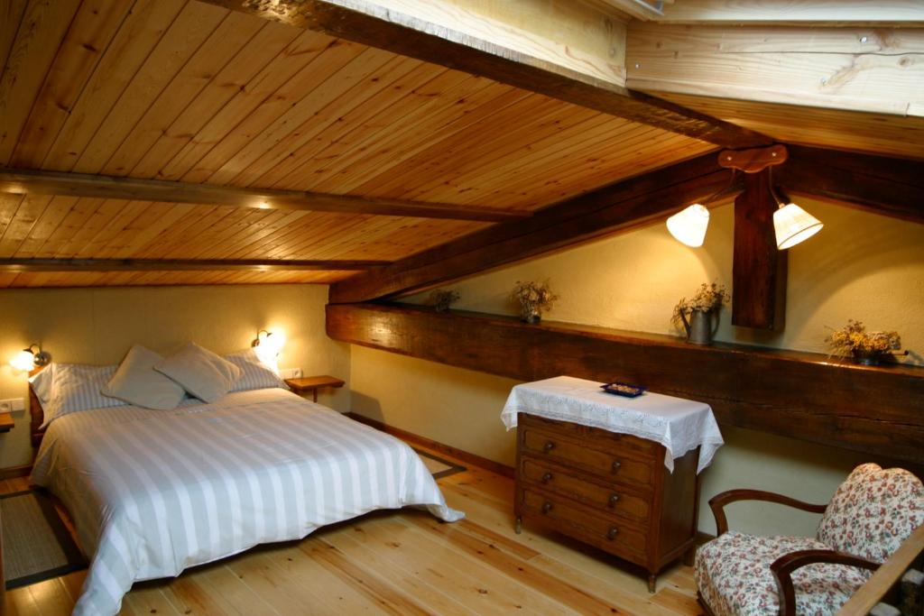 a bedroom with a bed and a wooden ceiling at Casa rural calRei in Lles