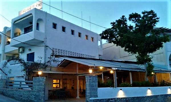 a white building with a tree in front of it at Attica Hotel Ephie in Souvala