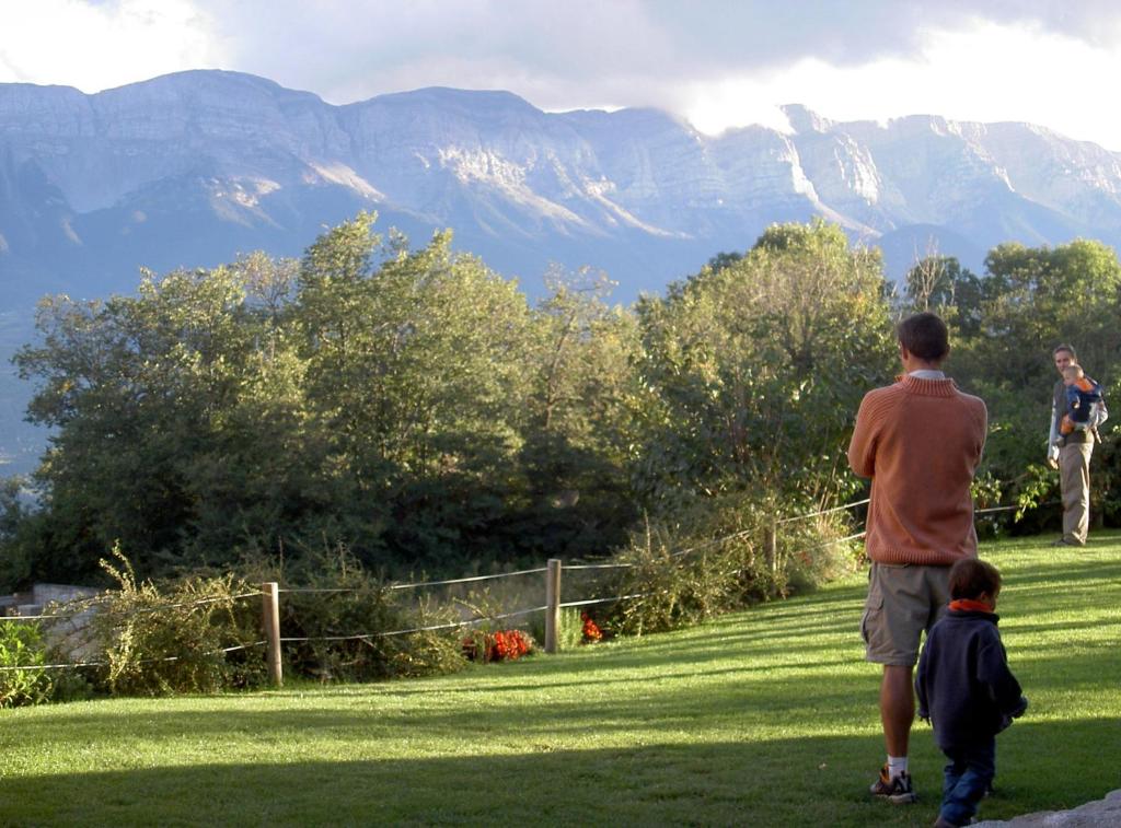 a man and a child flying a kite in a field at Casa rural calRei in Lles