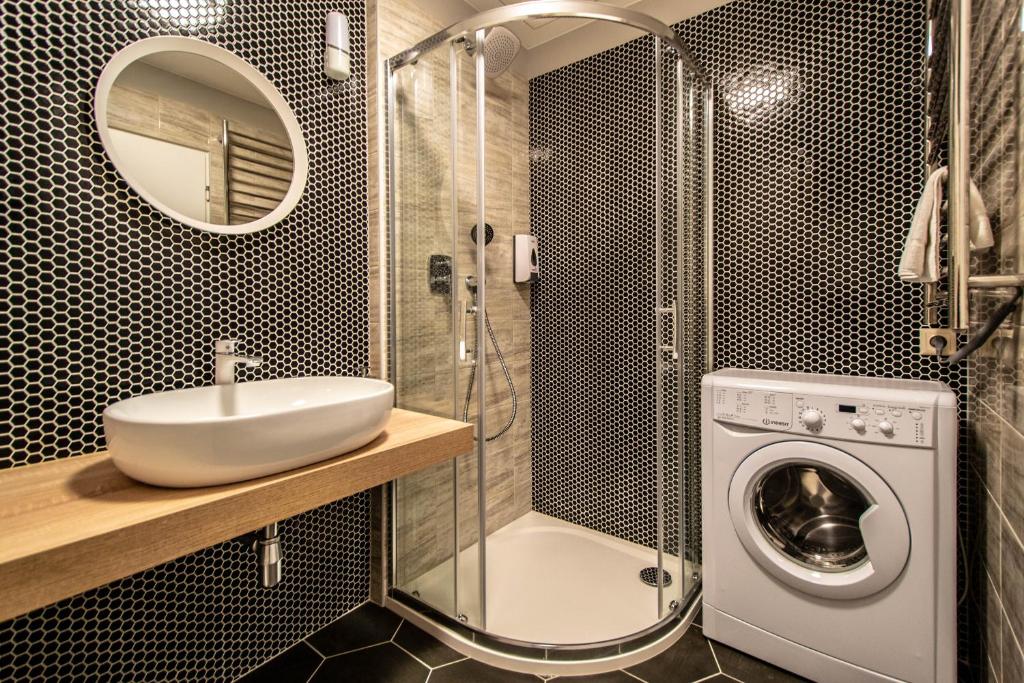 łazienka z umywalką i pralką w obiekcie Ruterra Apartment Cimburkova w Pradze