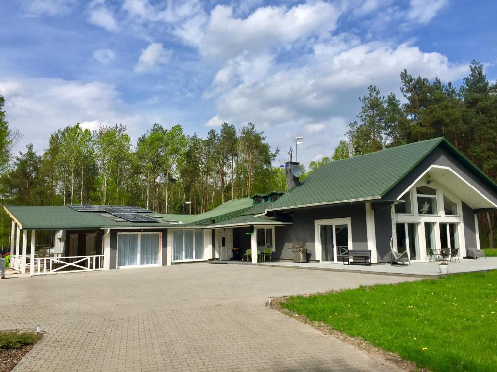 a house with a green roof and a driveway at Willa bankietowa z basenem in Papiernia