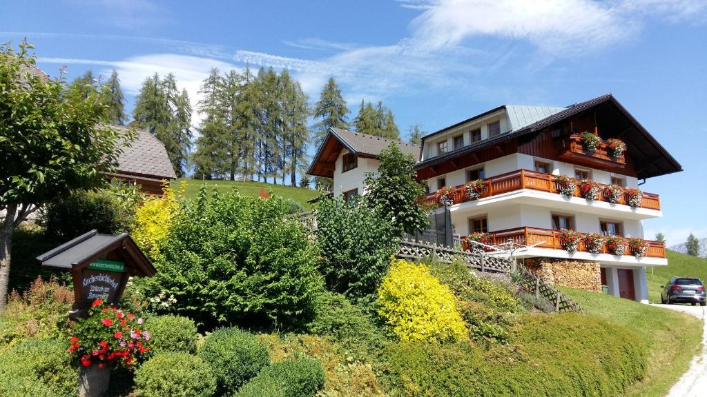 a house on the side of a hill with flowers at Kirchenbichlerhof in Pruggern