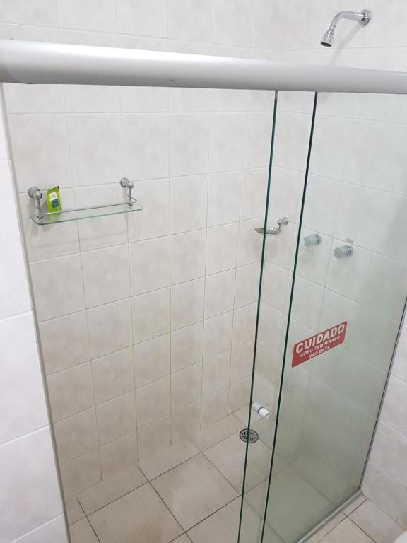 a shower with a glass door with a sticker on it at Hotel Valle Sul in Registro