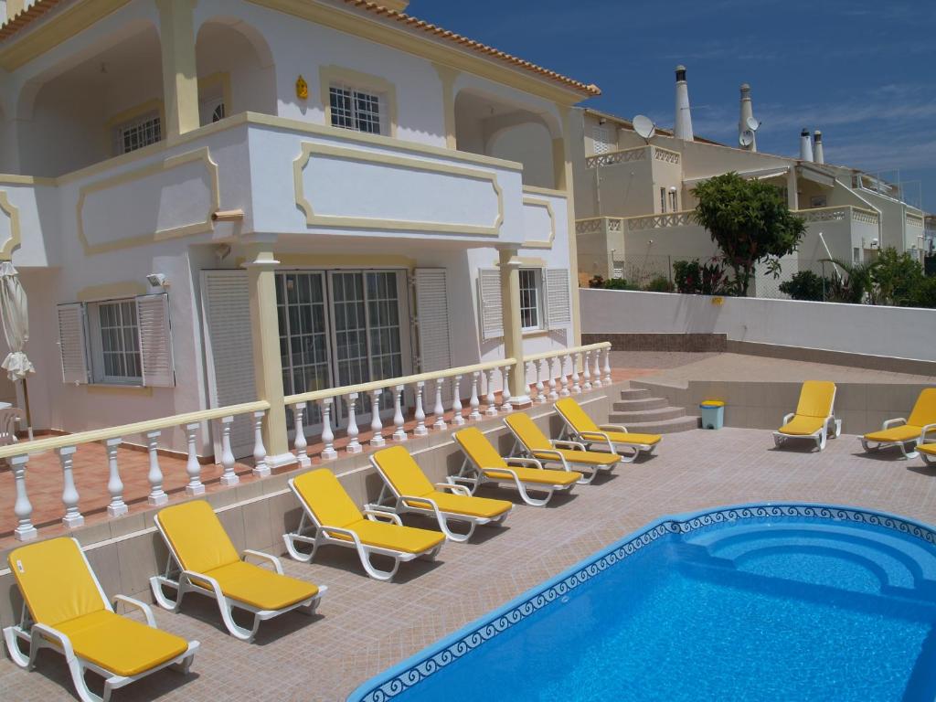 eine Gruppe von Stühlen neben einem Pool in der Unterkunft Villa Mariamar in Albufeira