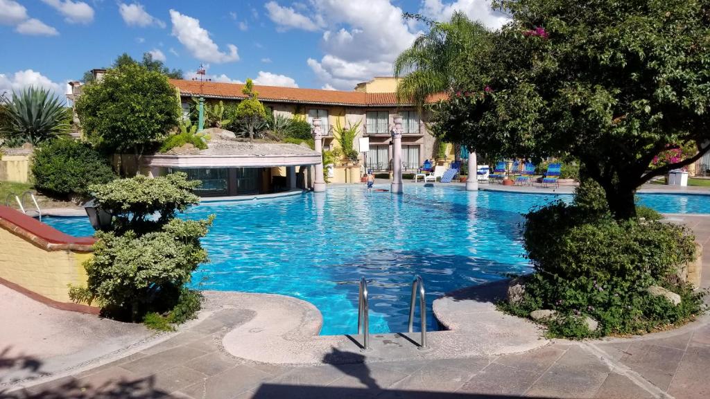 une grande piscine d'eau bleue en face d'un bâtiment dans l'établissement Gran Hotel Hacienda De La Noria, à Aguascalientes