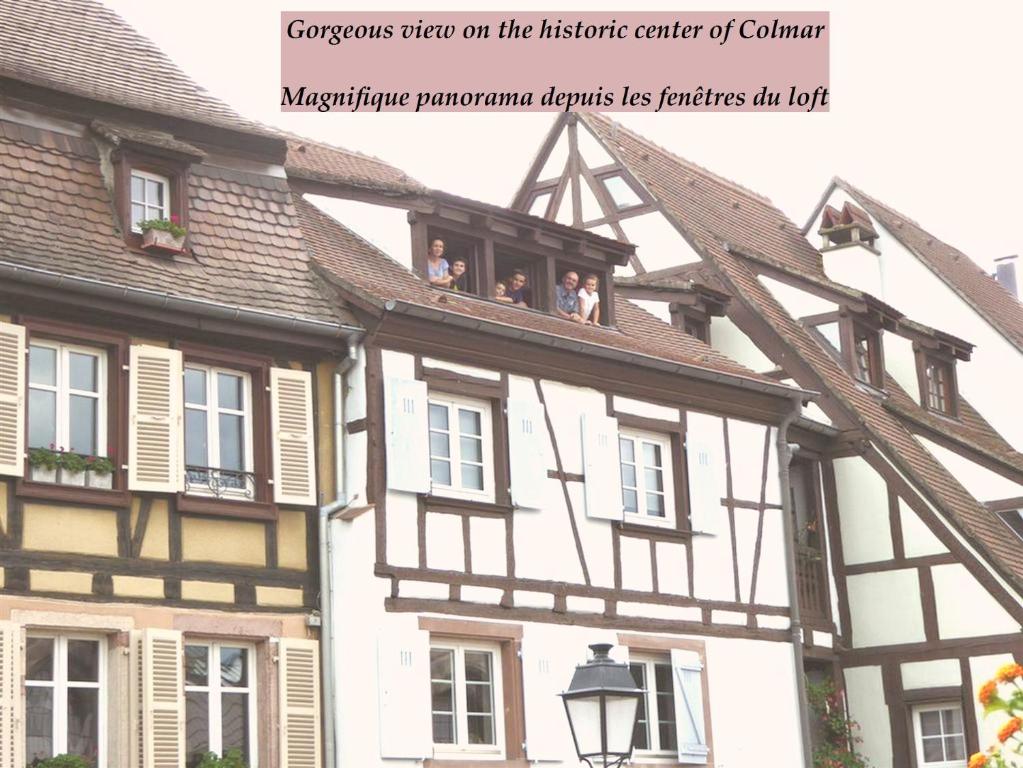 a group of people sitting on the balcony of a building at La Fabiola in Colmar