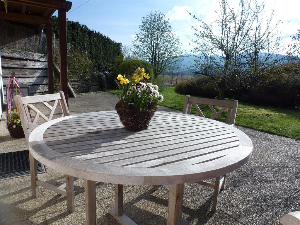 una mesa de madera con un jarrón de flores. en Ferienwohnung Christensen, en Murnau am Staffelsee