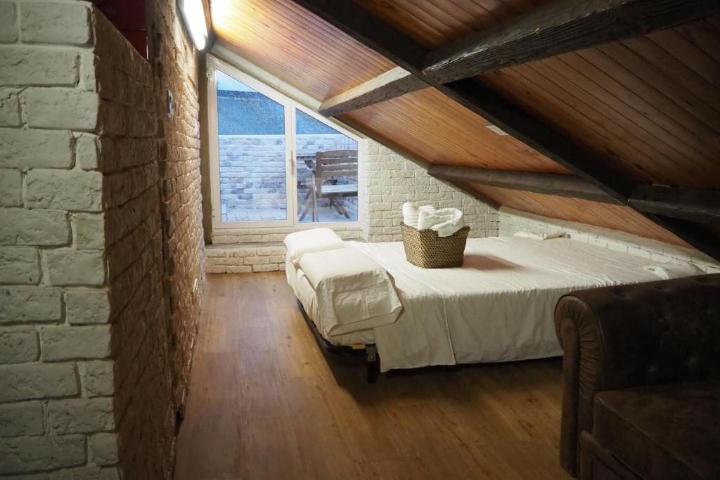 a bedroom with a white bed in a attic at Tiny and cute apartment in the roof touching border in La Línea de la Concepción