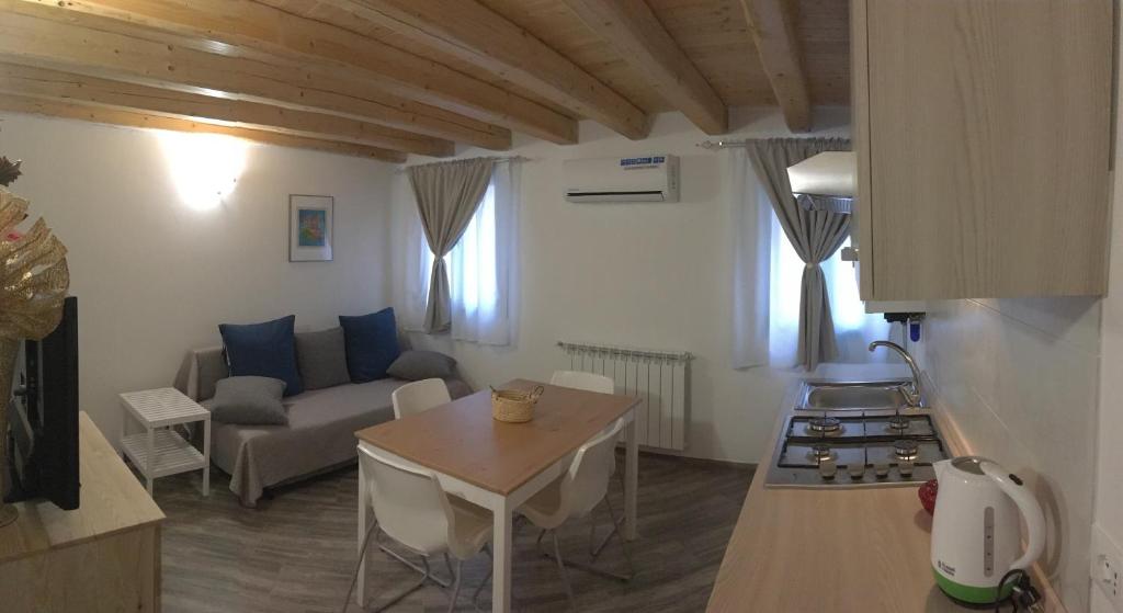 uma cozinha e sala de estar com um sofá e uma mesa em South Lagoon Apartments 1 em Chioggia