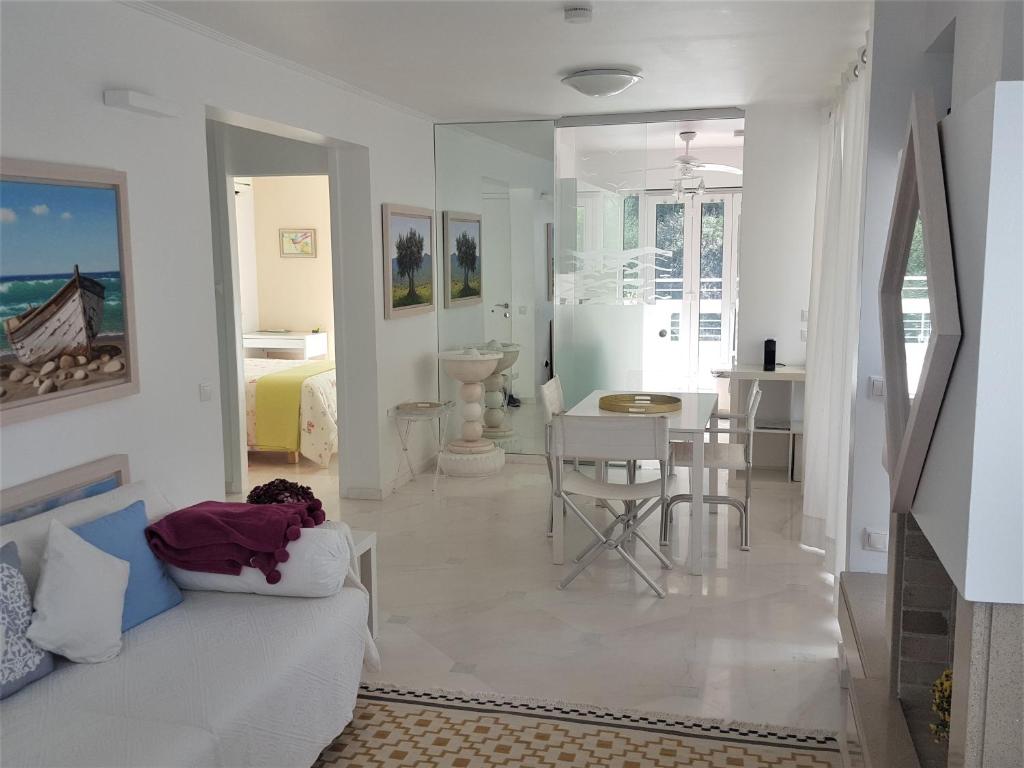 a living room with a white couch and a table at Sea View Dreamy Penthouse in Vouliagmeni in Athens