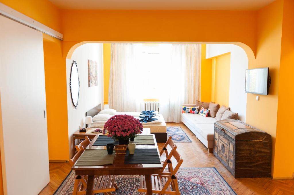 a living room with orange walls and a table at Vitosha Blvd - Family and Friends Apart in Sofia