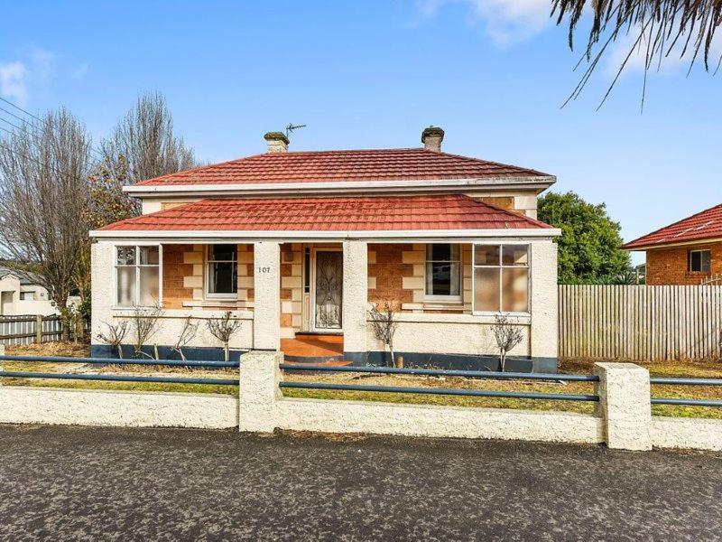 een stenen huis met een rood dak op een straat bij Olive's Cottage in Mount Gambier