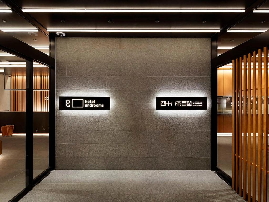 大阪市にあるホテル・アンドルームス新大阪の壁に看板が2つあるロビー