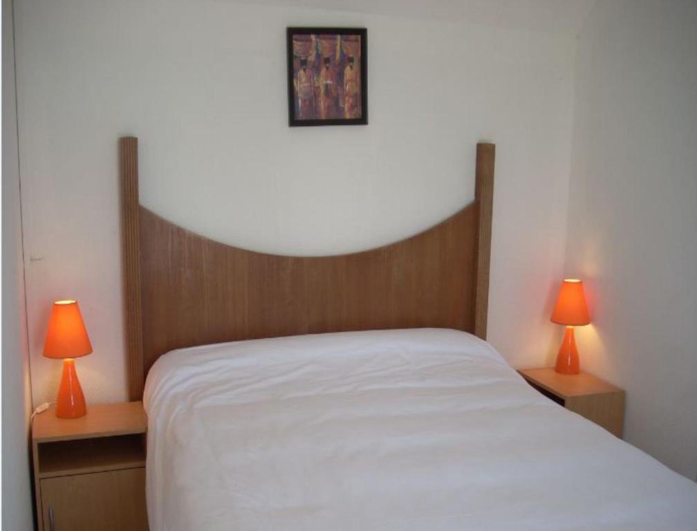 Vallères的住宿－薩爾住宿酒店，卧室配有带两盏灯的白色床